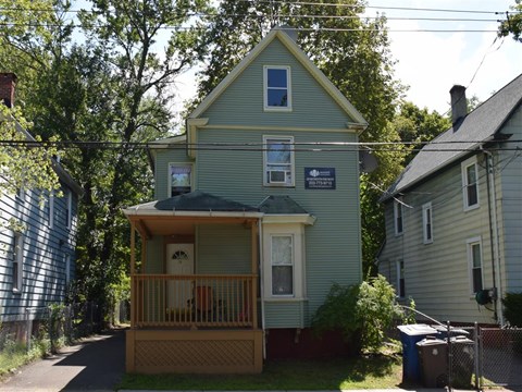 A house with a porch and a sign on the front.