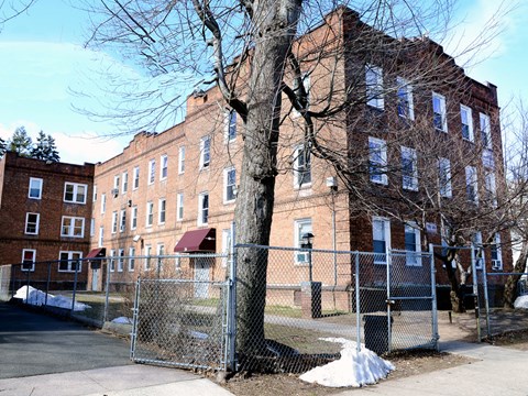 A large brick building with a fence in front of it.