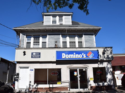 A Domino's Pizza restaurant with a blue and white signboard.