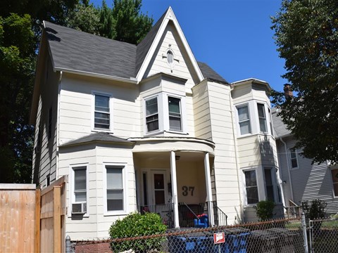 A two-story house with a white facade and a black roof.