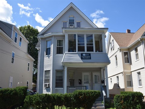 A two-story house with a porch and a balcony.