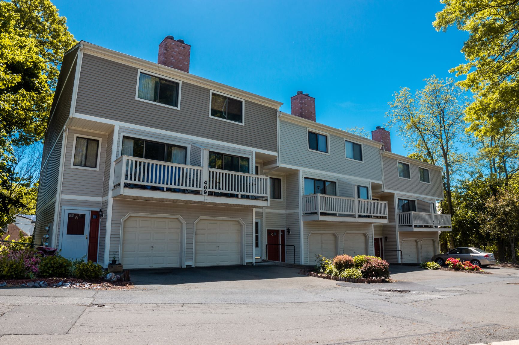 A large apartment building with a parking lot in front.