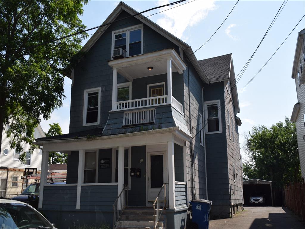 A two-story house with a balcony on the second floor.