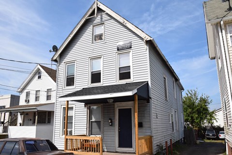 A two-story house with a car parked in front.