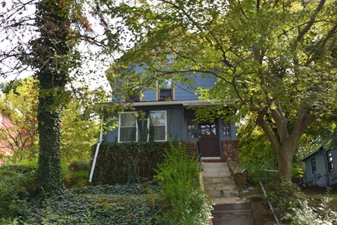 A house with a staircase leading to the front door.