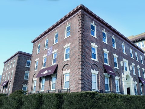 A red brick building with white trim and awnings.
