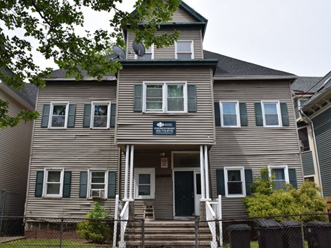 A two-story house with a front porch and a garage door.