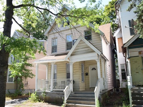 A house with a white porch and a brown door.