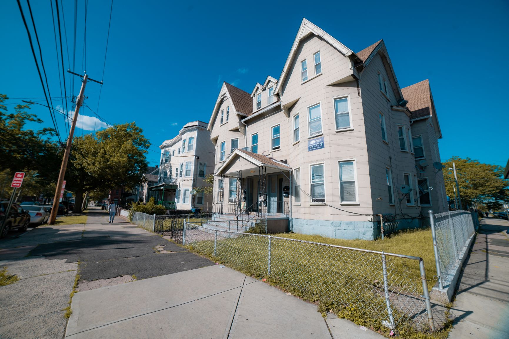 A large, two-story house with a fenced front yard.