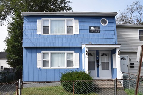 A blue house with a white door and windows.