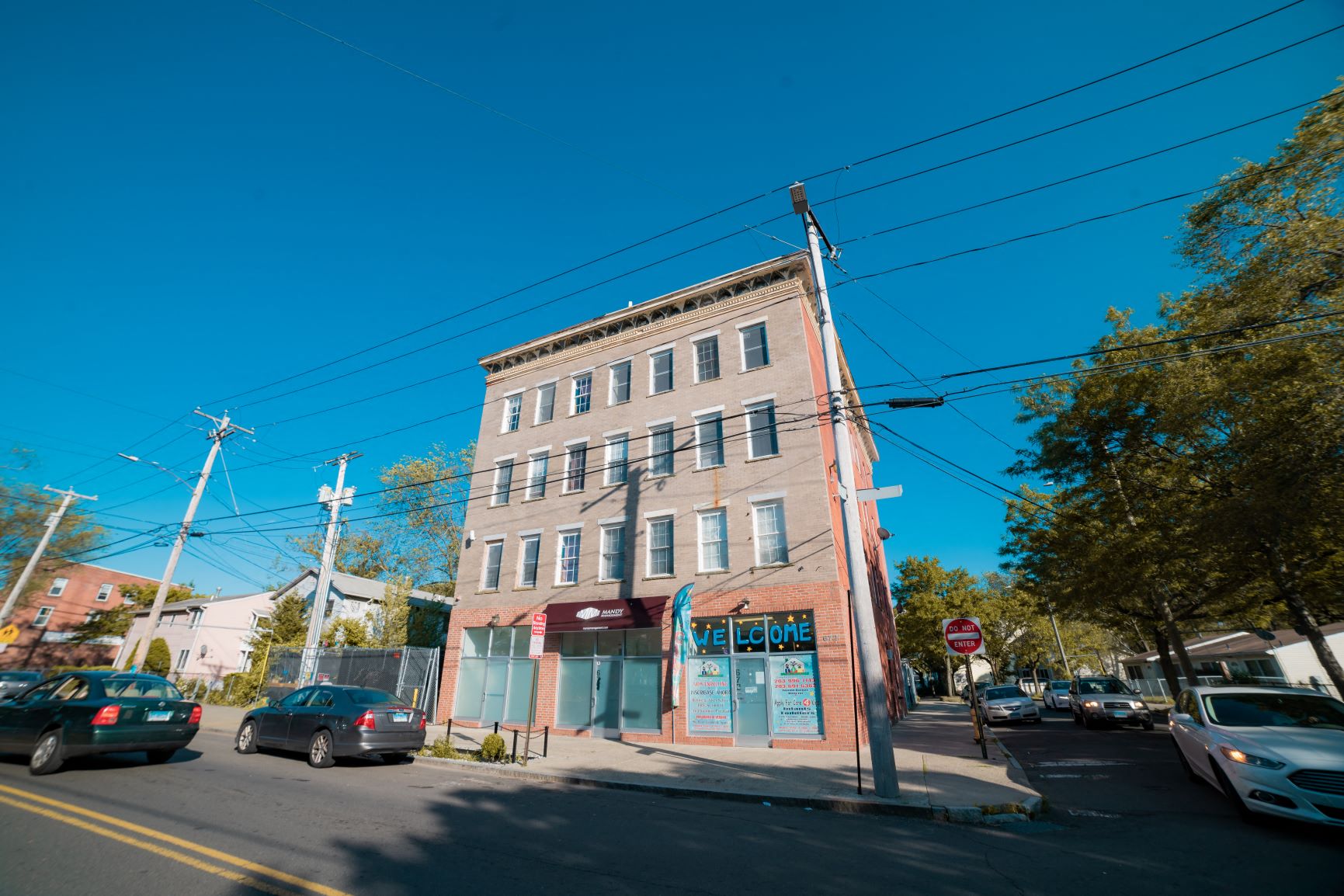 A street view of a building with a sign that says "Welcome".