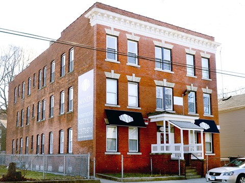 A red brick building with a white sign on the front.