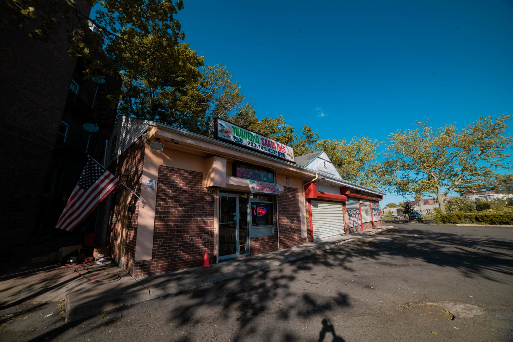 A small building with a red awning and an American flag hanging on the left side.