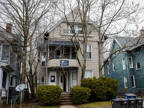 A house with a blue sign in front of it.