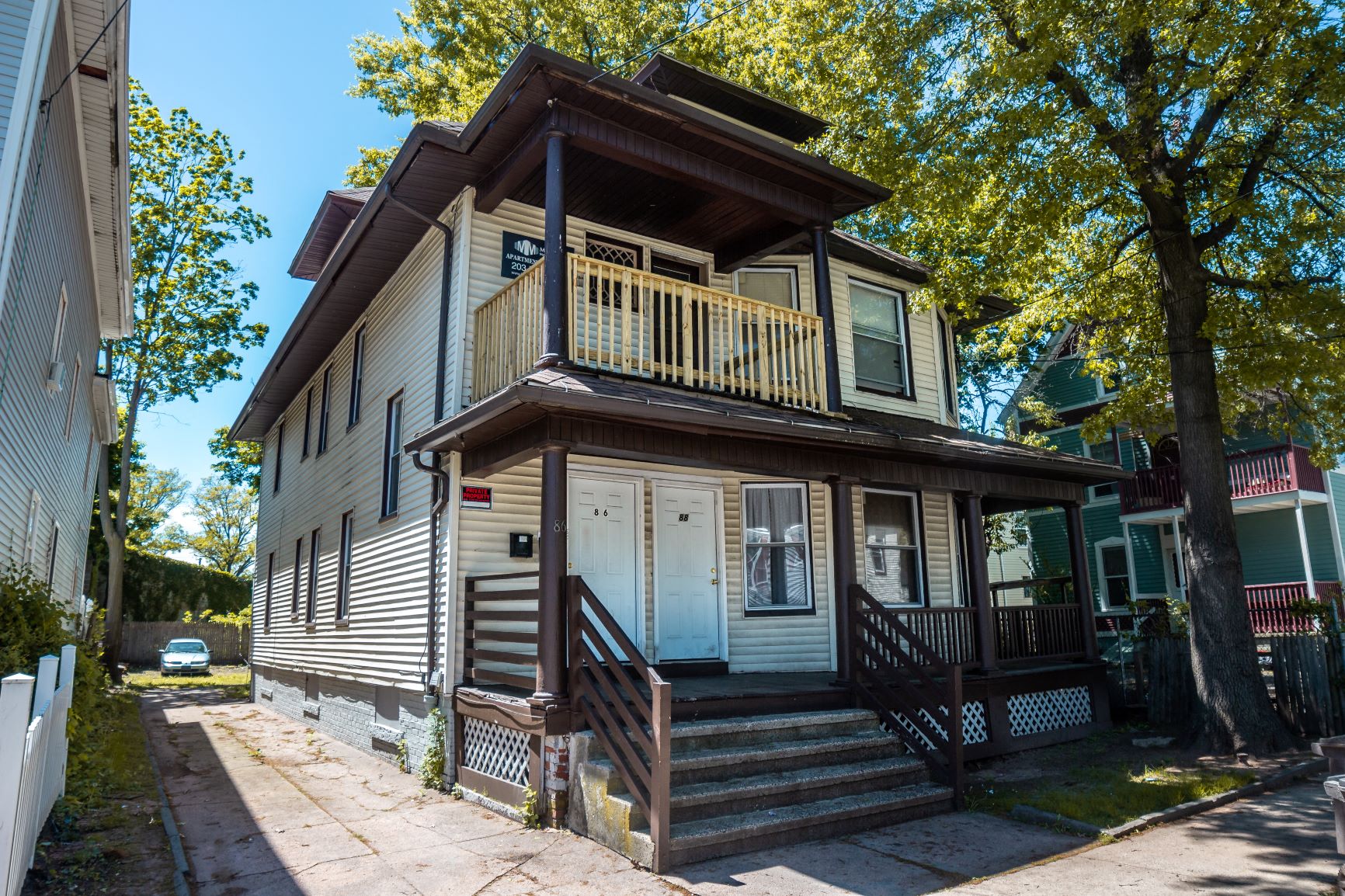 A two-story house with a balcony on the second floor.