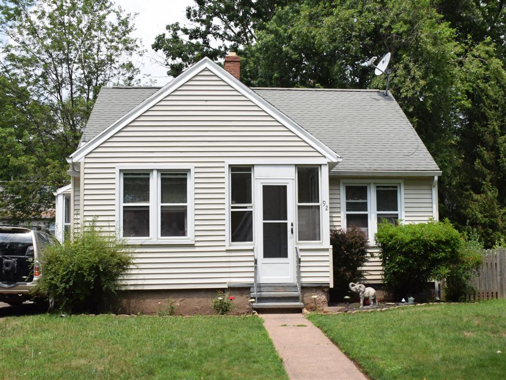 A small white house with a grey roof and a grey door.