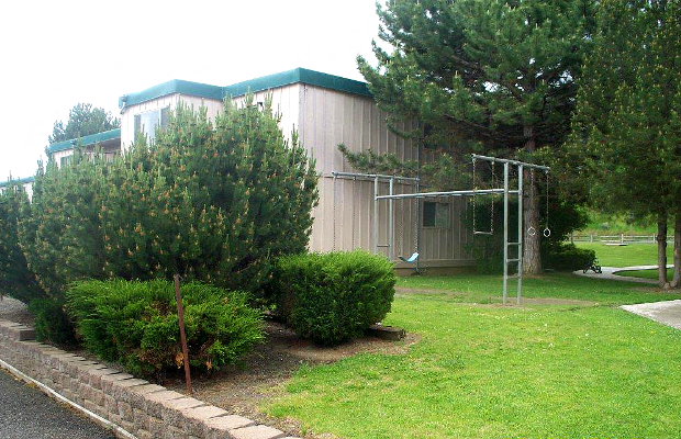 a building with trees and bushes in front of it