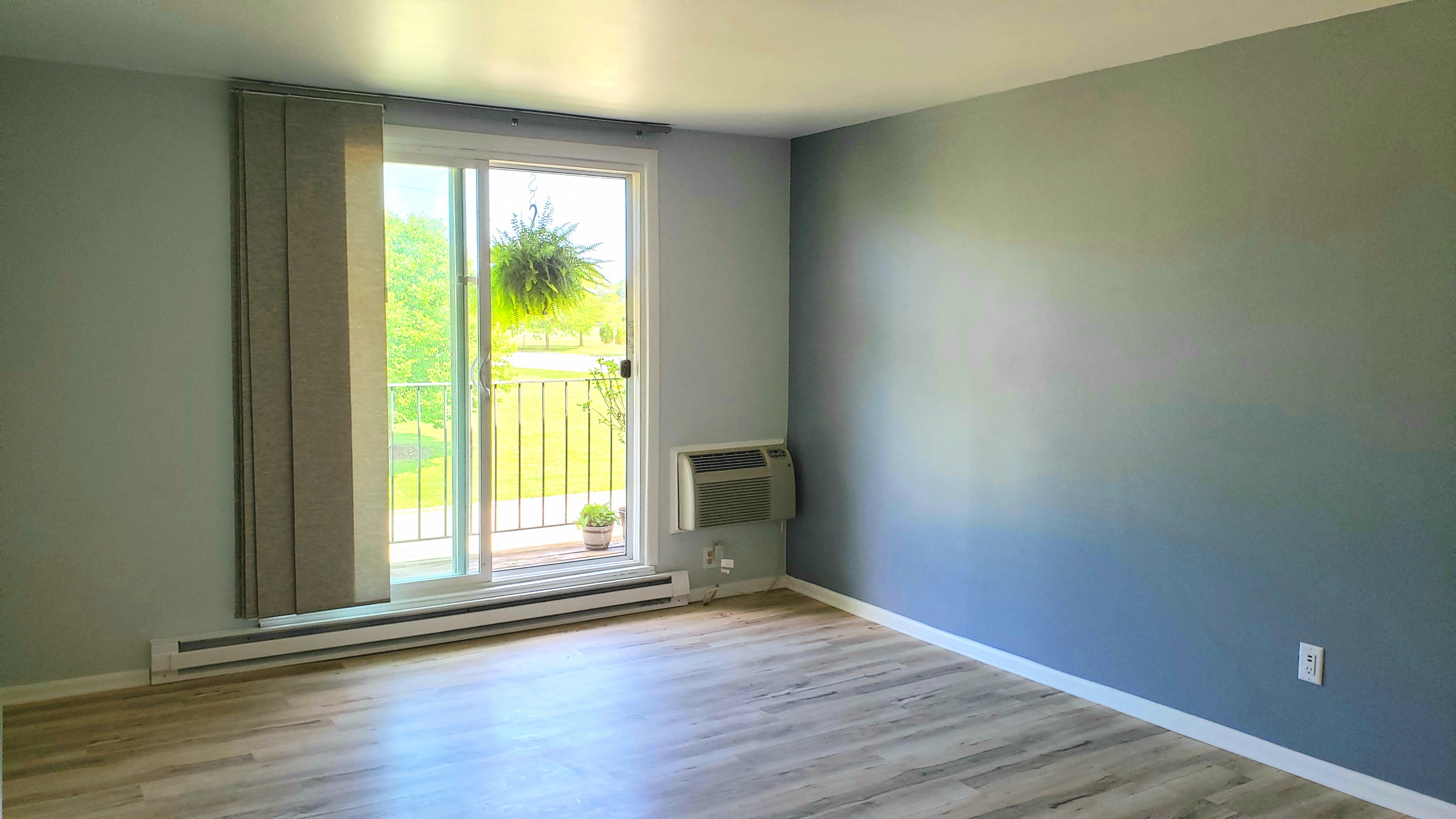 a room with gray walls and a door to a balcony
