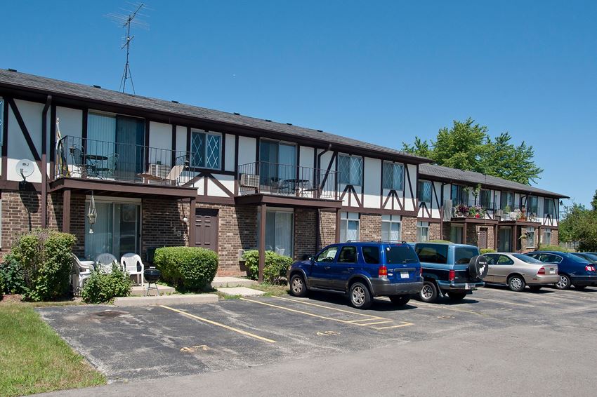 an apartment building with cars parked in front of it
