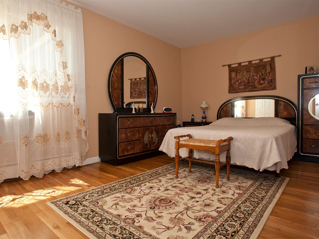 a bedroom with a bed and a dresser and a mirror