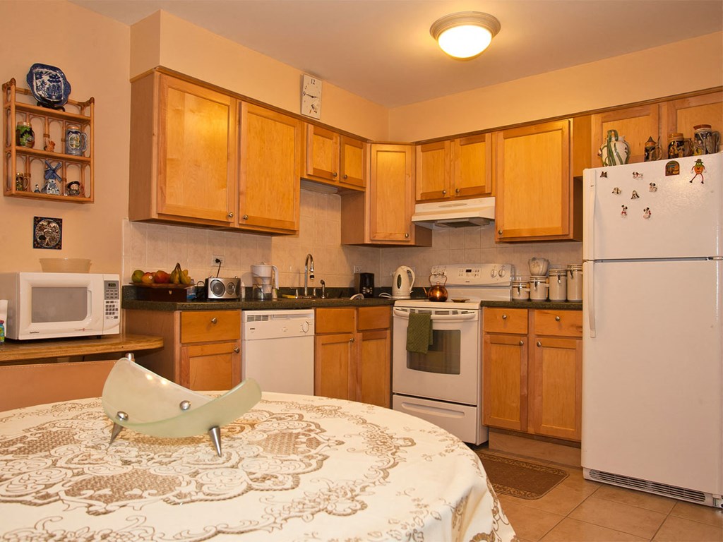 a kitchen with a table and a refrigerator