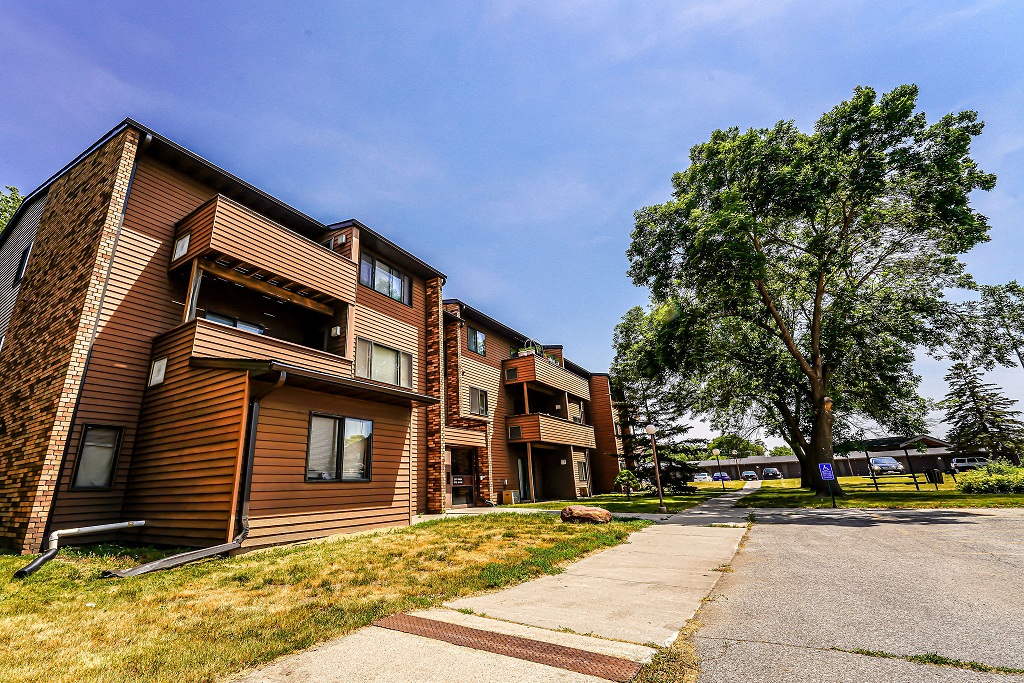 a row of apartment buildings on the side of a street