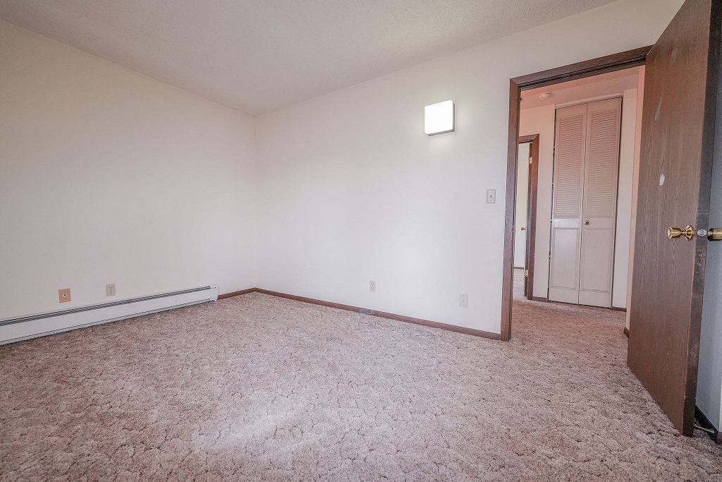 an empty living room with a door to a hallway