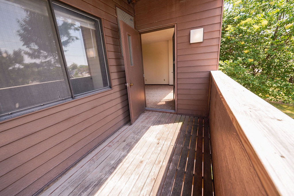the deck of a cabin with a large window and a door