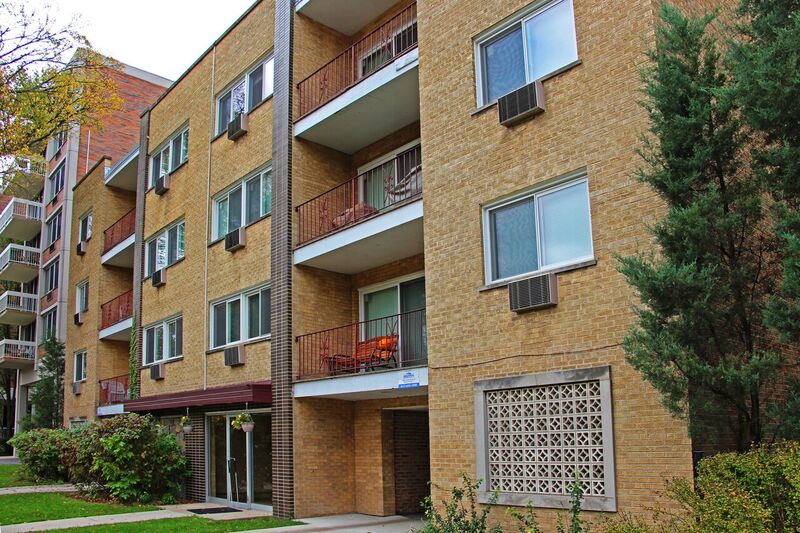 A brick apartment building with balconies and windows.