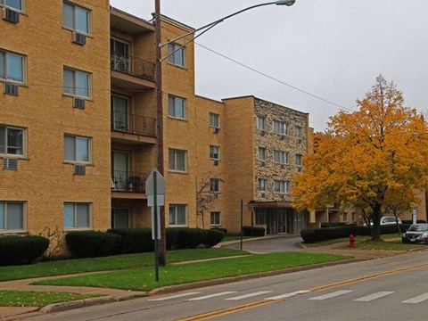 a yellow brick apartment building on the corner of a street