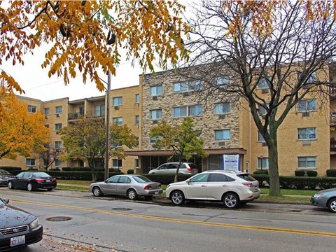 an apartment building with cars parked in front of it