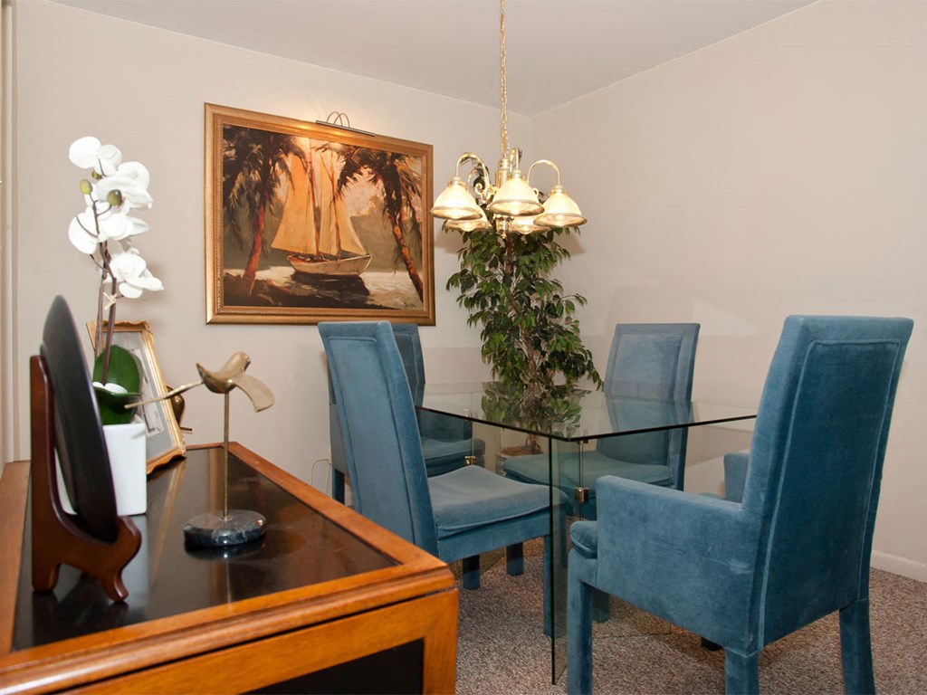 a dining room with a glass table and blue chairs