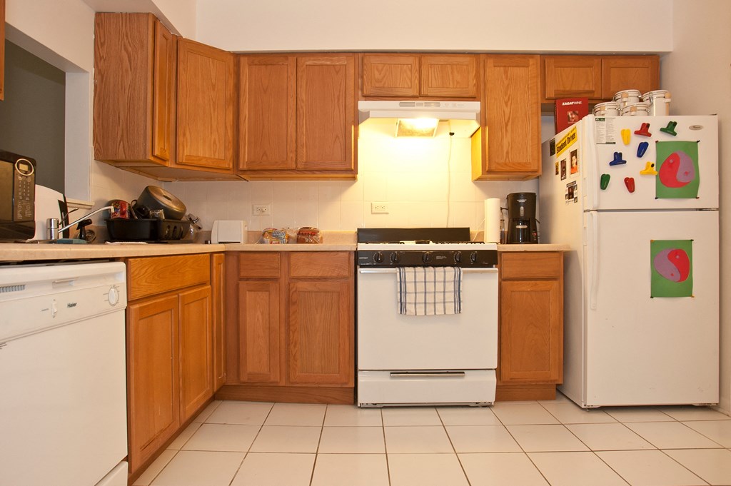 a kitchen with white appliances and wooden cabinets
