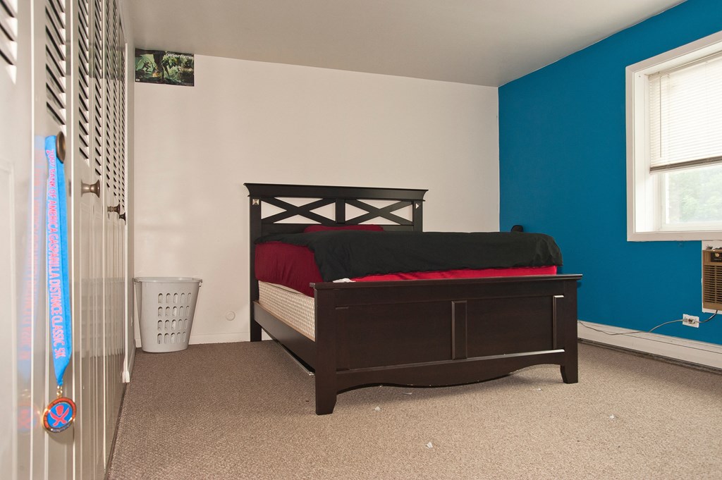 a bedroom with a bed and a blue wall