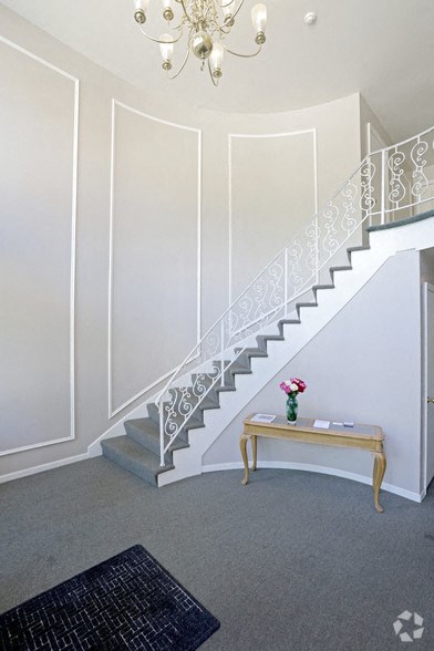 a staircase in a white room with a table