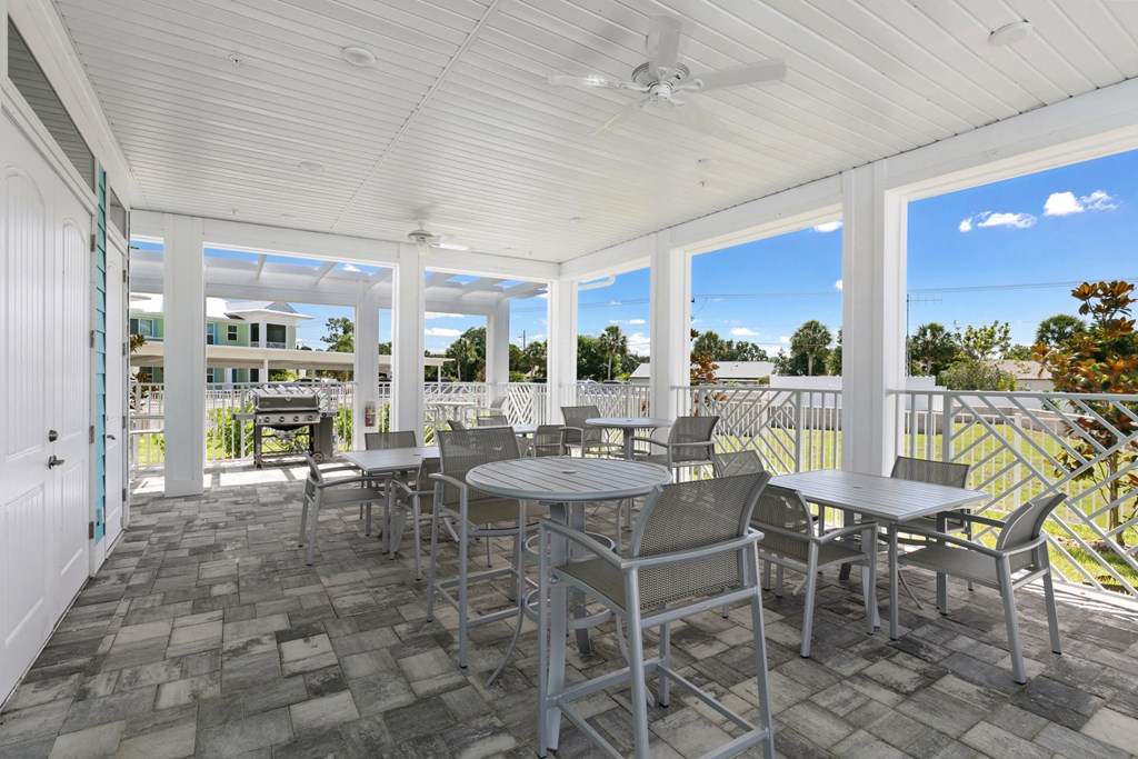 a covered patio with tables and chairs