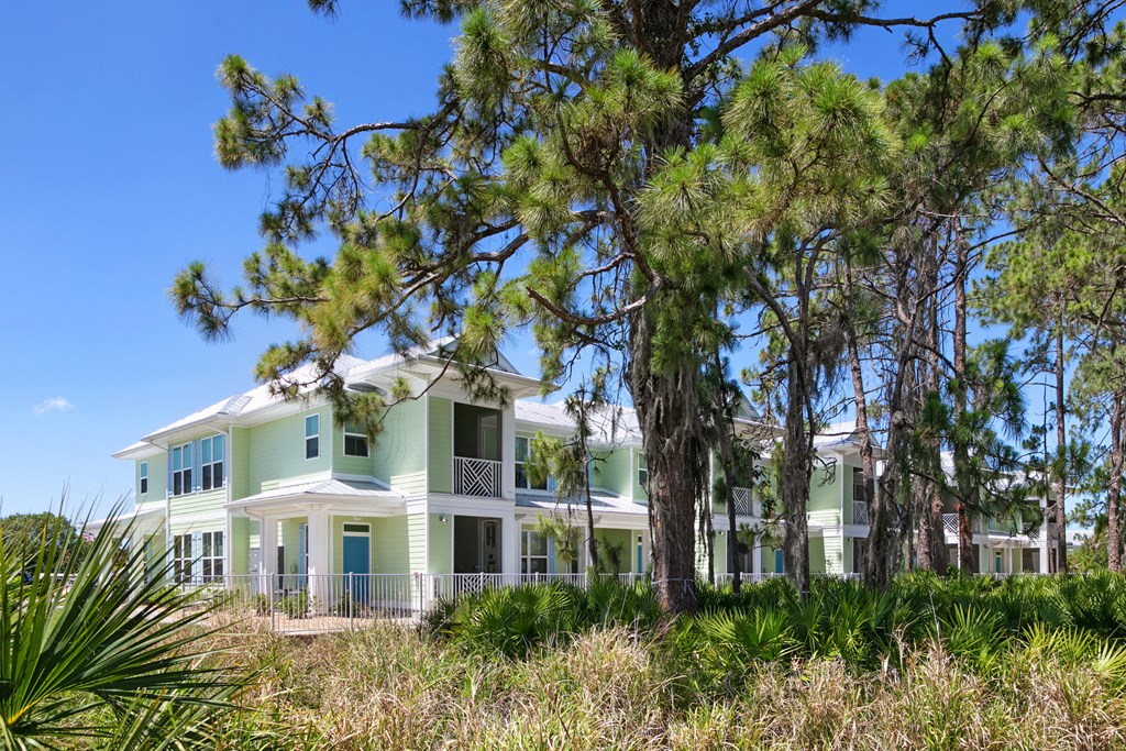 a large green house with trees in front of it