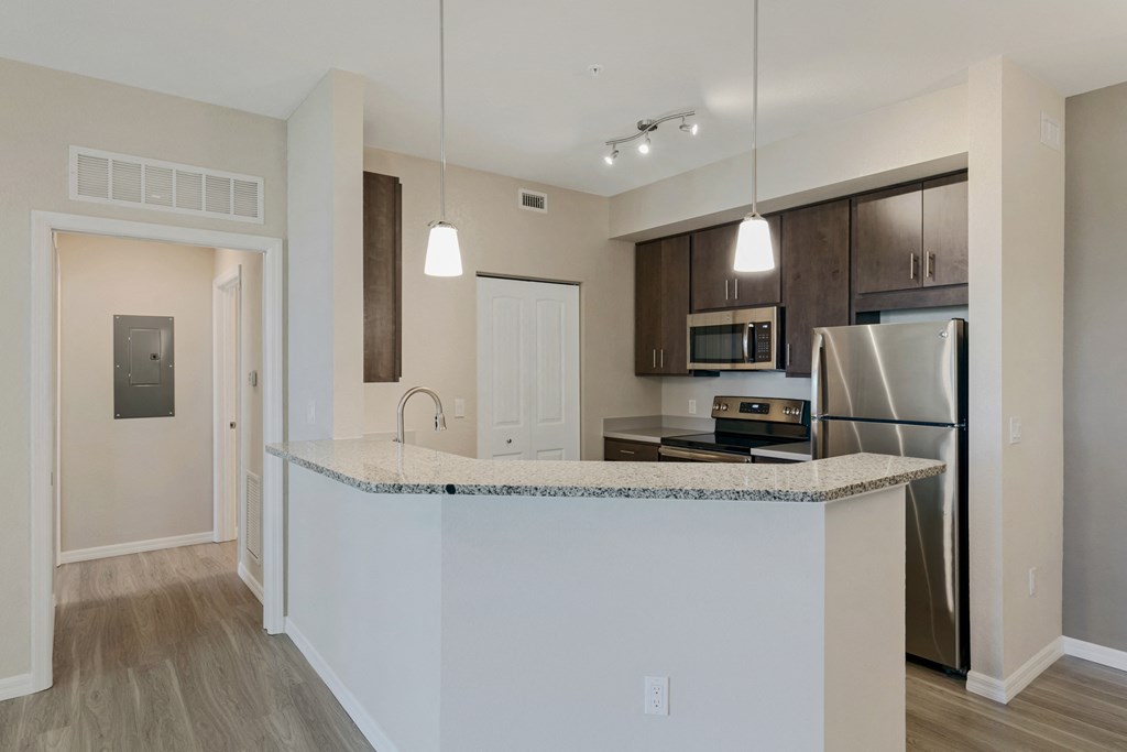 a kitchen with an island and a stainless steel refrigerator