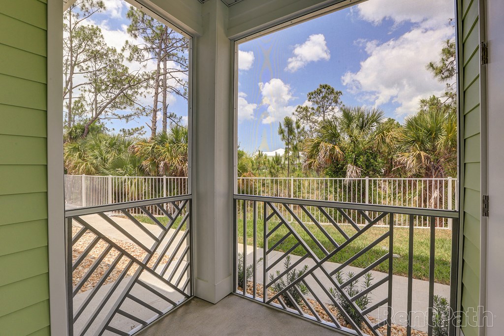a balcony with a view of a yard and palm trees