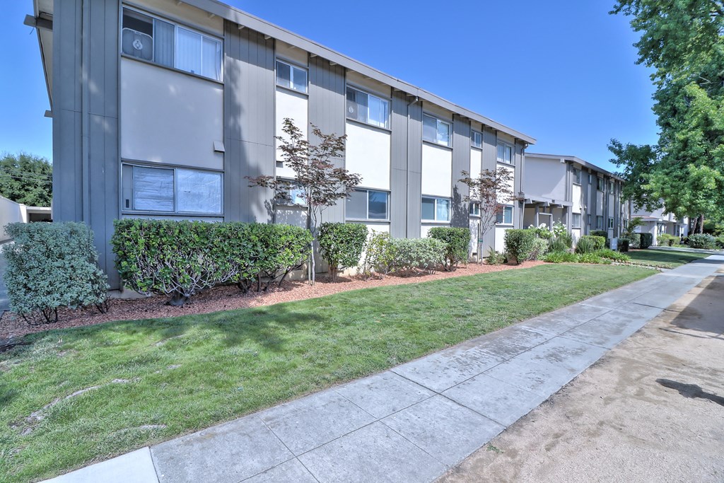 an apartment building with a sidewalk in front of it