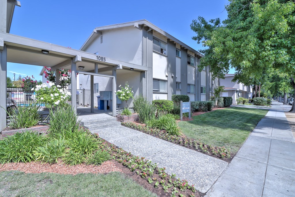 an exterior view of a building with a sidewalk and grass