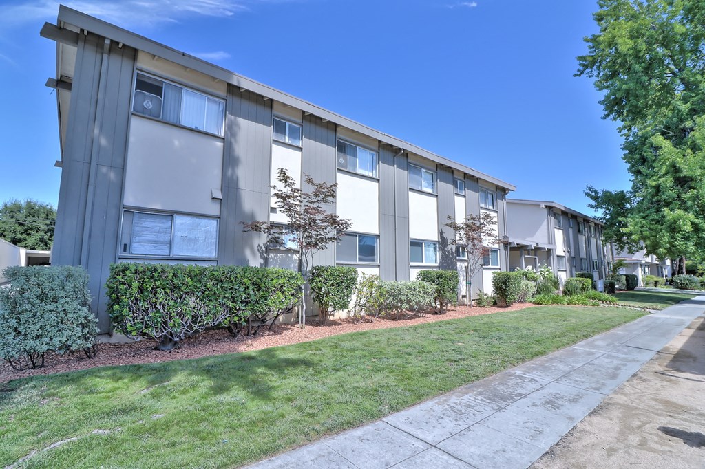 an apartment building with a sidewalk in front of it