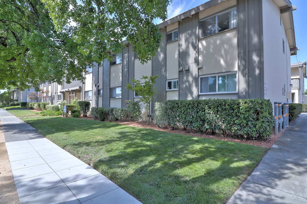 an apartment building with a sidewalk in front of it