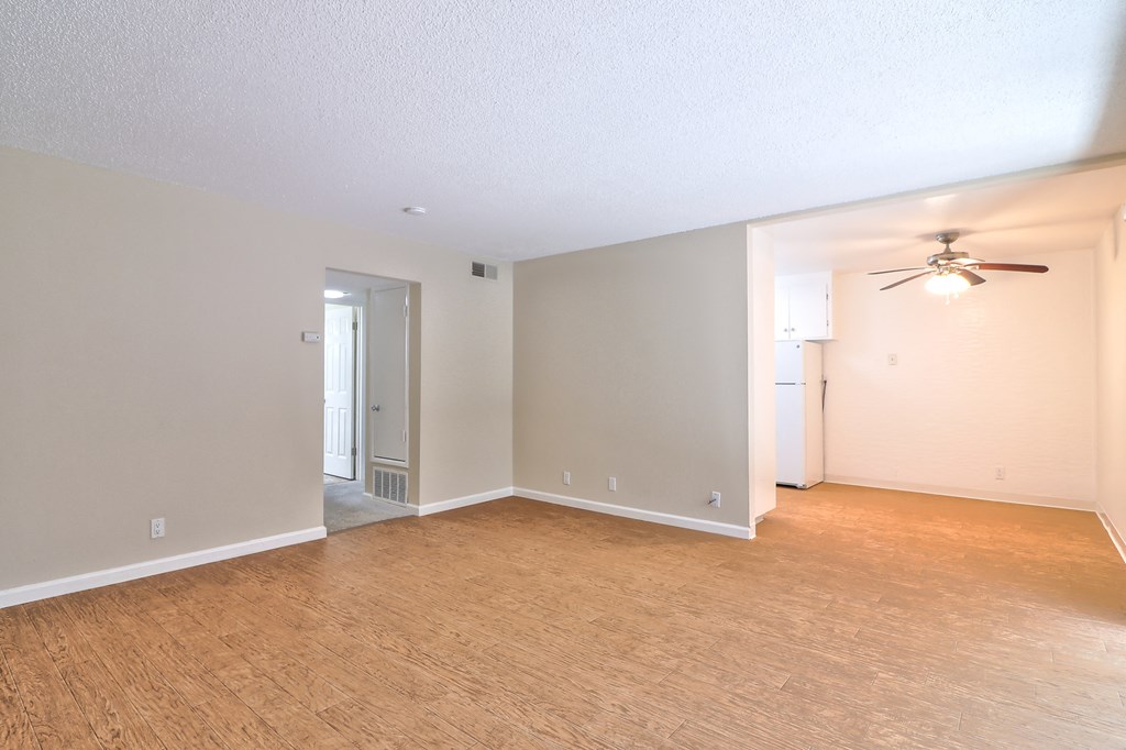 an empty living room with a ceiling fan and a wood floor