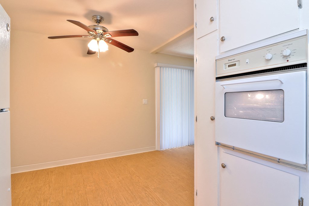 a kitchen with an oven and a ceiling fan