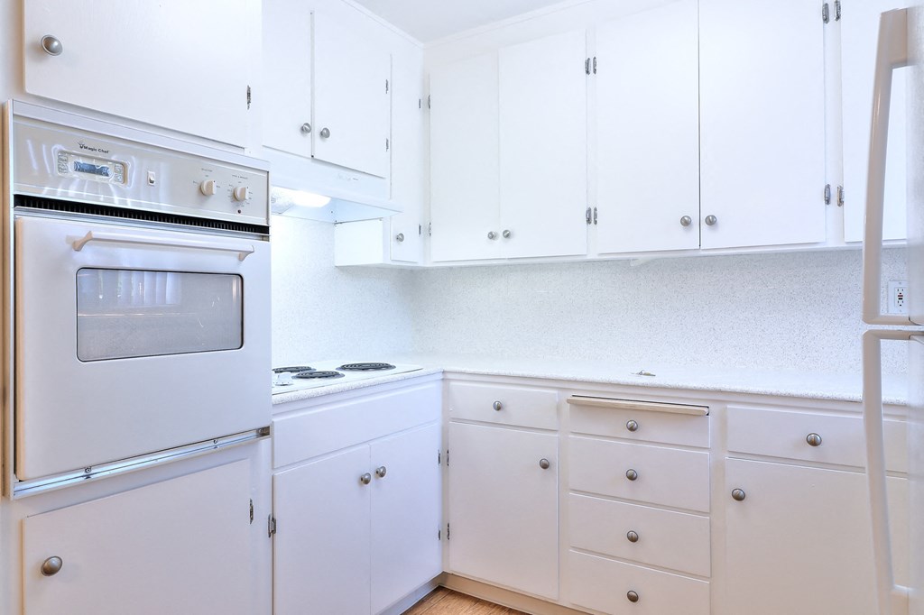 A white kitchen with a stove and oven.