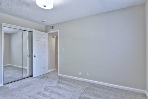A room with a carpeted floor and a white door.