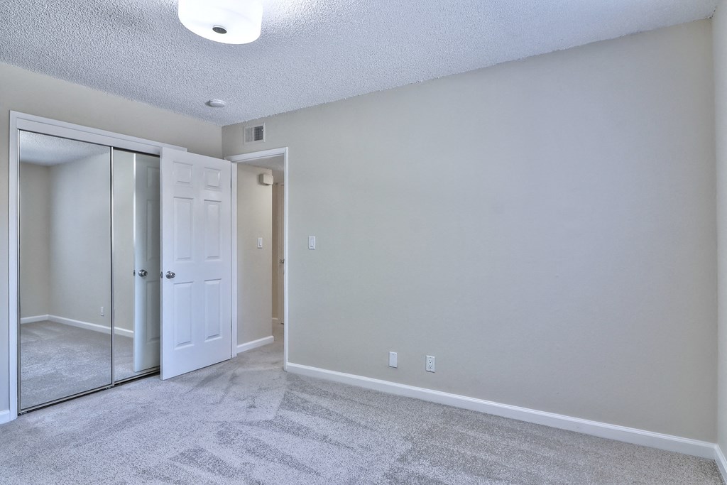 A room with a carpeted floor and a white door.