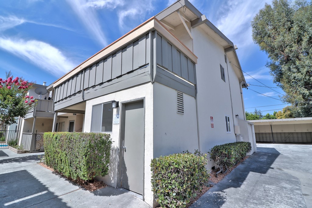 the front of a white building with a garage door