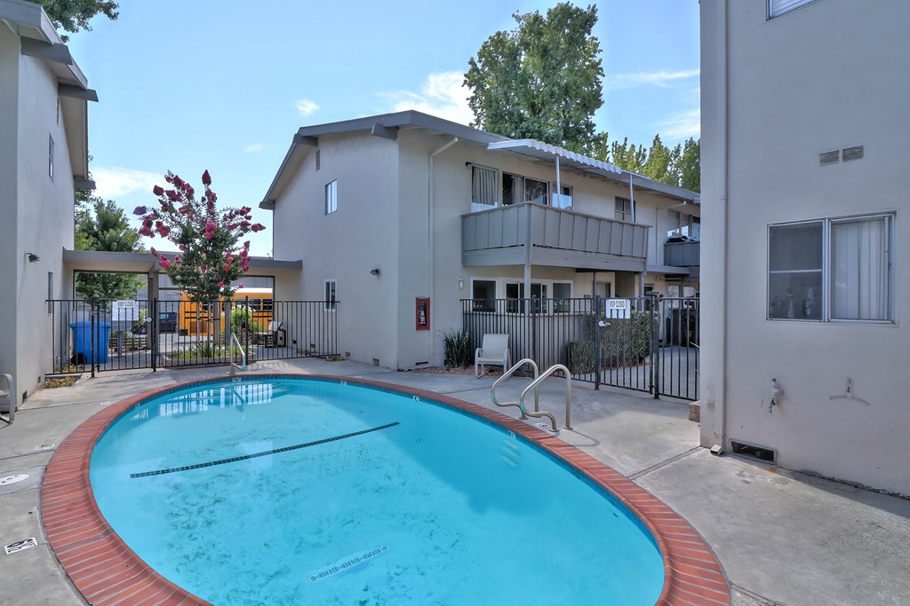 A small pool in a courtyard surrounded by buildings.